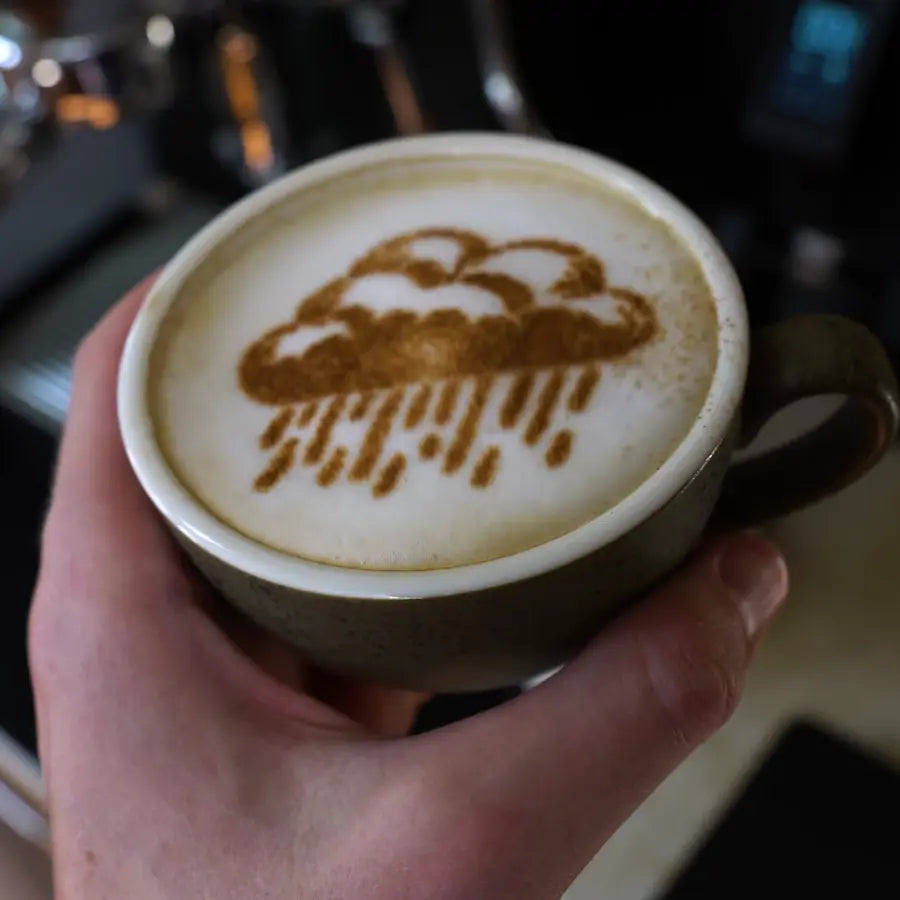 Capuchino con una nube de lluvia dibujada con canela